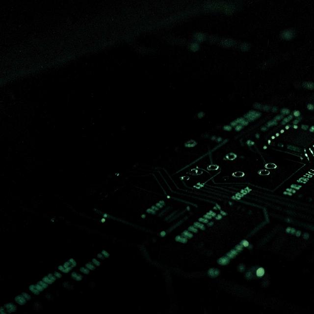 Close-up of a circuit board glowing faintly green