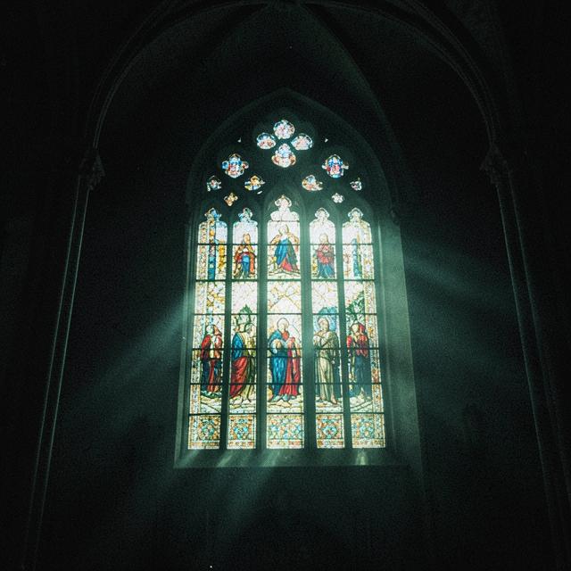 Stained glass window in a dim cathedral